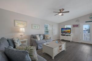 a living room with a couch and a tv at Canario Cottage Home in Anna Maria