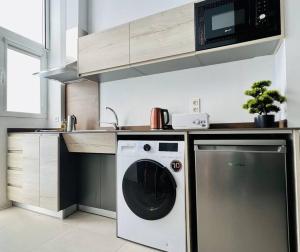 a kitchen with a washing machine and a microwave at Exclusive LOFT in Ruzafa (SOHO) in Valencia