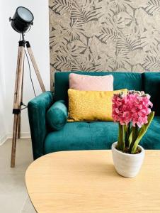 sala de estar con sofá verde y mesa con flores en Exclusive LOFT in Ruzafa (SOHO), en Valencia