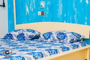 Una cama con almohadas azules y blancas. en HAPPY GUEST HOUSE - HGH en Abomey-Calavi