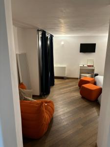 ローマにあるBoutique rooms trastevereのリビングルーム(オレンジ色のソファ2台、テレビ付)