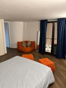 ローマにあるBoutique rooms trastevereのベッドルーム1室(ベッド1台、オレンジ色の椅子2脚付)