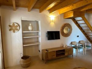 a living room with a tv and a wooden table at Casa Bella in Playa Migjorn