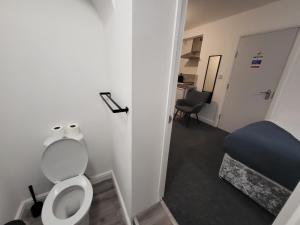 a small bathroom with a toilet and a bed at Premier Studios Nottingham - Tring Vale in Nottingham