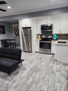 eine Küche mit Küchengeräten aus Edelstahl und einer schwarzen Couch in der Unterkunft Blue Shark *H12* @ River Oaks Modern 1BR King Apartment in Houston