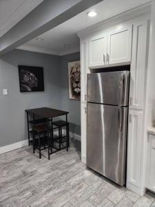 eine Küche mit einem Kühlschrank aus Edelstahl und einem Tisch in der Unterkunft Blue Shark *H12* @ River Oaks Modern 1BR King Apartment in Houston