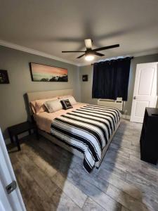 Schlafzimmer mit einem Bett und einem Deckenventilator in der Unterkunft Blue Shark *H12* @ River Oaks Modern 1BR King Apartment in Houston