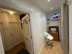 Cette chambre dispose d'une porte blanche et d'une télévision murale. dans l'établissement Double Room With Free WiFi Keedonwood Road, à Bromley