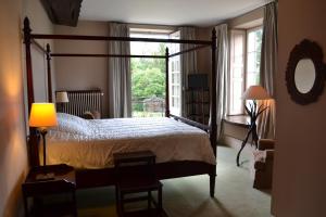 a bedroom with a canopy bed and a window at Le Manoir de Villefermoy in Les Écrennes
