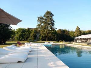 uma piscina com uma mesa e um guarda-sol em Le Manoir de Villefermoy em Les Écrennes