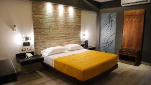 a bedroom with a large bed and a brick wall at Hotel Myst. in Monterrey