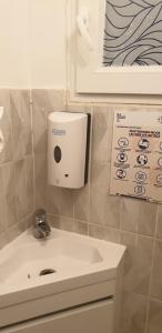 een badkamer met een wastafel en een zeepdispenser aan de muur bij Room Calaisis #1 bed in Calais