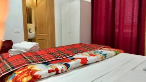 - un lit avec une couverture colorée dans l'établissement I Dormienti, à Rome