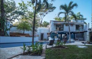 カリージョにあるCasa Guarumo - An oasis in Playa Carrillo.のヤシの木とスイミングプールのある家