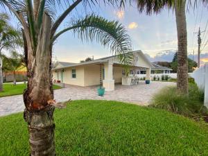 a palm tree in front of a house at TOP RATED! Namaste Here steps to Flagler & Beach in New Smyrna Beach