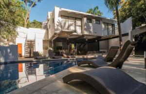 una casa con piscina al lado de un edificio en Casa Guarumo - An oasis in Playa Carrillo., en Carrillo