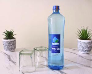 SIMBA'S NOOK - A modern Budget Studio Apartment in Syokimau, Nairobi with Fast WiFi & Netflix - Near the JKIA Airport, SGR Station & Gateway Mall في Syokimau: وجود زجاجة مياه جالسة بجانب كأسين