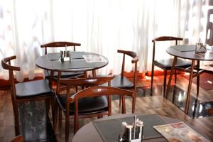 a group of tables and chairs in a restaurant at Orchid Suites, Kira in Bulindo