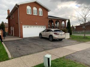 a car parked in a driveway in front of a house at SUMPTUOUS HOUSE IN BEAUTIFUL NEIGHBORHOOD in Brampton