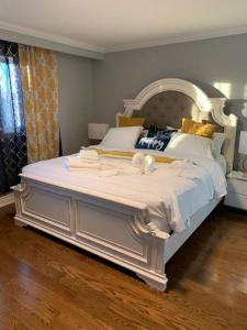 a bedroom with a large bed with white sheets and pillows at SUMPTUOUS HOUSE IN BEAUTIFUL NEIGHBORHOOD in Brampton