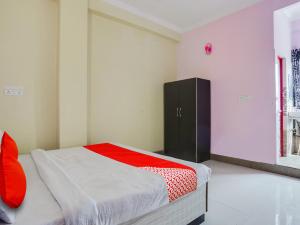 a bedroom with a bed and a black cabinet at OYO Flagship Radhe Radhe Hotels in Kānpur