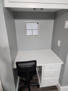 Blue Shark *G1* @ Montrose Urban 1BR King Apartment في هيوستن: مكتب أبيض مع كرسي أسود في غرفة