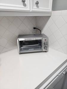 een broodrooster met oven bovenop een aanrecht bij Blue Shark *G1* @ Montrose Urban 1BR King Apartment in Houston