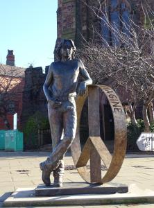 una estatua de un joven parado frente a una señal en Stylish & modern home across the road from the famous Penny Lane walking distance to cafes restaurants and supermarkets en Liverpool