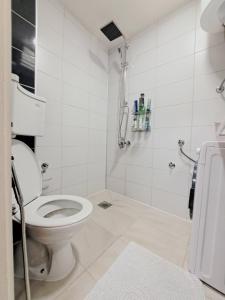 een witte badkamer met een toilet en een douche bij Apartman EM in Sarajevo
