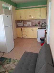 a kitchen with yellow cabinets and a white refrigerator at Mountain View Apartments #10 in Glanvillia