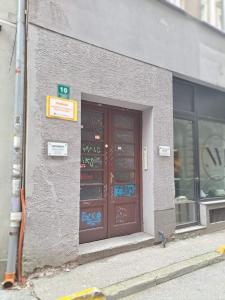 een gebouw met twee deuren met graffiti erop bij Apartman EM in Sarajevo