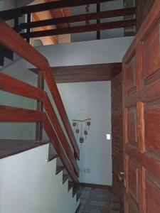 a spiral staircase in a house with a wooden door at CHE LOLITA HOUSE 3 in El Palomar