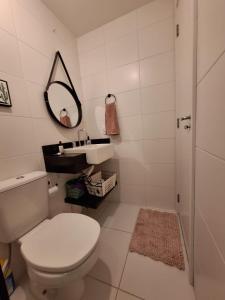 a white bathroom with a toilet and a sink at Laguna Linda Vista in São Paulo