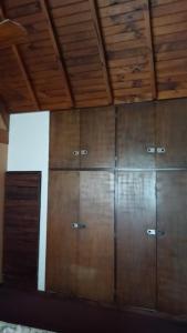 rząd drewnianych szafek w pokoju z sufitem w obiekcie CHE LOLITA HOUSE 3 w mieście El Palomar