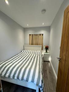 sypialnia z łóżkiem z kołdrą i oknem w obiekcie 1 bed with kitchenette and bathroom w Oksfordzie