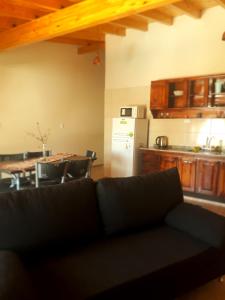 sala de estar con sofá, mesa y cocina en Departamentos San Benito en Malargüe