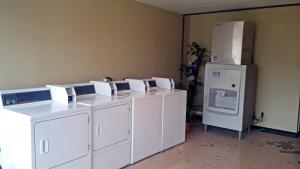 un grupo de lavadoras y secadoras en una habitación con nevera en Motel 6-Brunswick, GA, en Brunswick
