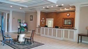 una sala de espera con mesa y espejo en Motel 6-Brunswick, GA, en Brunswick