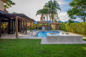 un patio trasero con piscina y una casa en Villas Panaca Portal 1 en Quimbaya