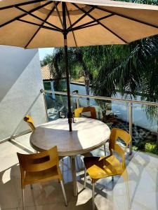 a table and chairs with an umbrella on a balcony at Casa Tamarindo in Alpuyeca