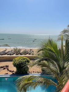 - une vue sur la plage avec un palmier et l'océan dans l'établissement La maison du bonheur, à Ouoran