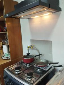 una cocina con ollas y sartenes en una estufa en Apartamento cerca del Humedal Tres Puentes, en Punta Arenas