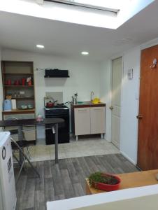 a kitchen with a table and a stove top oven at Apartamento cerca del Humedal Tres Puentes in Punta Arenas