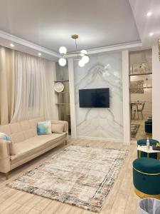 uma sala de estar com um sofá e uma televisão na parede em Madinaty, Elite new studio families and married couples only em Madinaty