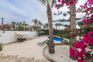 a patio with palm trees and a swimming pool at Casa Blanca la Villa Grande - SWIMMING POOL - JACUZZI XXL - BEACH 2,4km - AIRPORT 12 km - CENTER 1km in Gran Alacant +36 photos