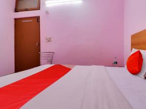 Hotel Yug Residency في حاريدوار: غرفة نوم بسرير من اللون الاحمر والابيض