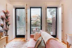 - un salon avec un canapé et de grandes fenêtres dans l'établissement SUN CHARMING APARTMENT, à Porto