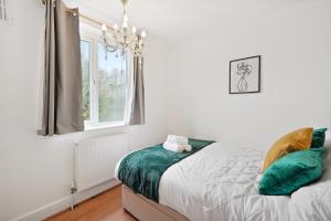 a bedroom with a bed and a chandelier at Dunstable 3 bedroom house with Free Parking in Dunstable
