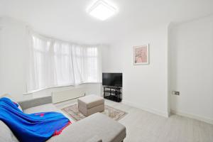 ein Wohnzimmer mit einem Sofa und einem TV in der Unterkunft Dunstable 3 bedroom house with Free Parking in Dunstable