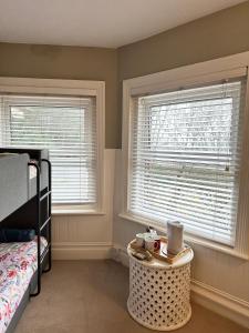 a bedroom with two windows and a bed and a table at The Boho - 4 min walk to beach & town in Bournemouth